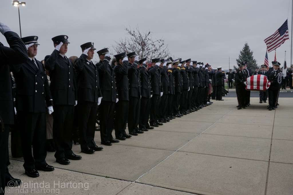 Hamilton firefighters salute as their fellow firefighters carry Firefighter Patrick Wolterman in to the services at Princeton Pike Church of God ©Malinda Hartong