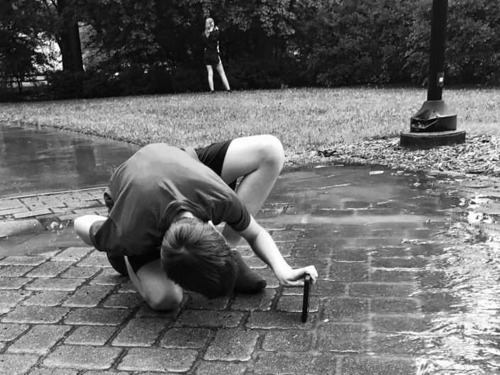 a teen takes a photo with his phone during summer camp with smart phone photography